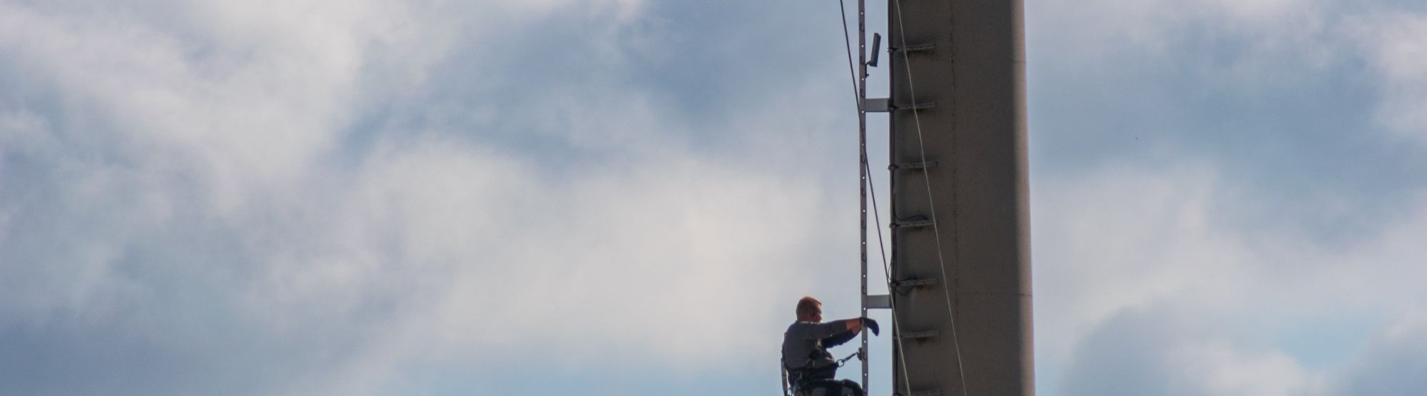 Technician climbing a telecom tower during maintenance