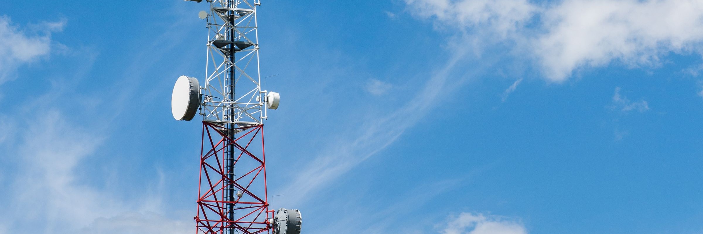 Telecom tower against a clear blue sky, with open sky to the right